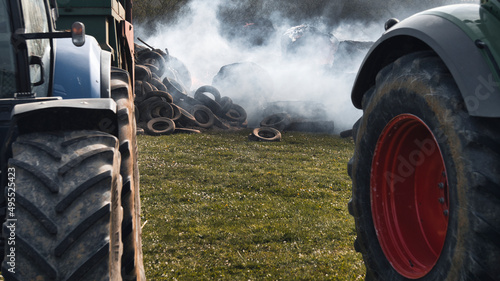 Agricultural tractors and burning tires, demonstration on the cost of fuel. Close up