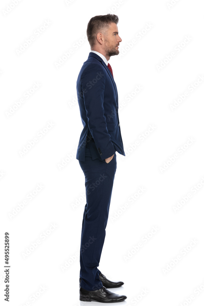 businessman waiting in line, holding his hands in pockets businessman waiting in line, holding his hands in pockets