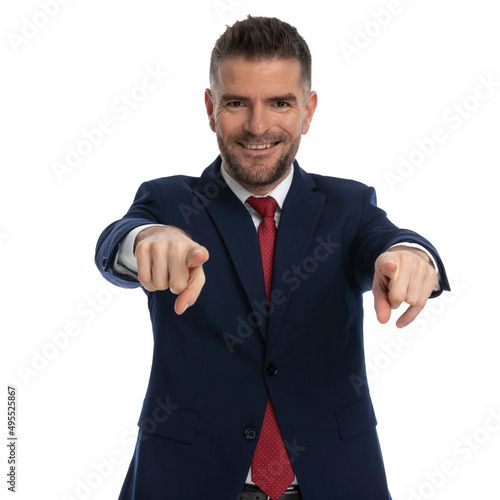 attractive businessman pointing at the camera with both hands