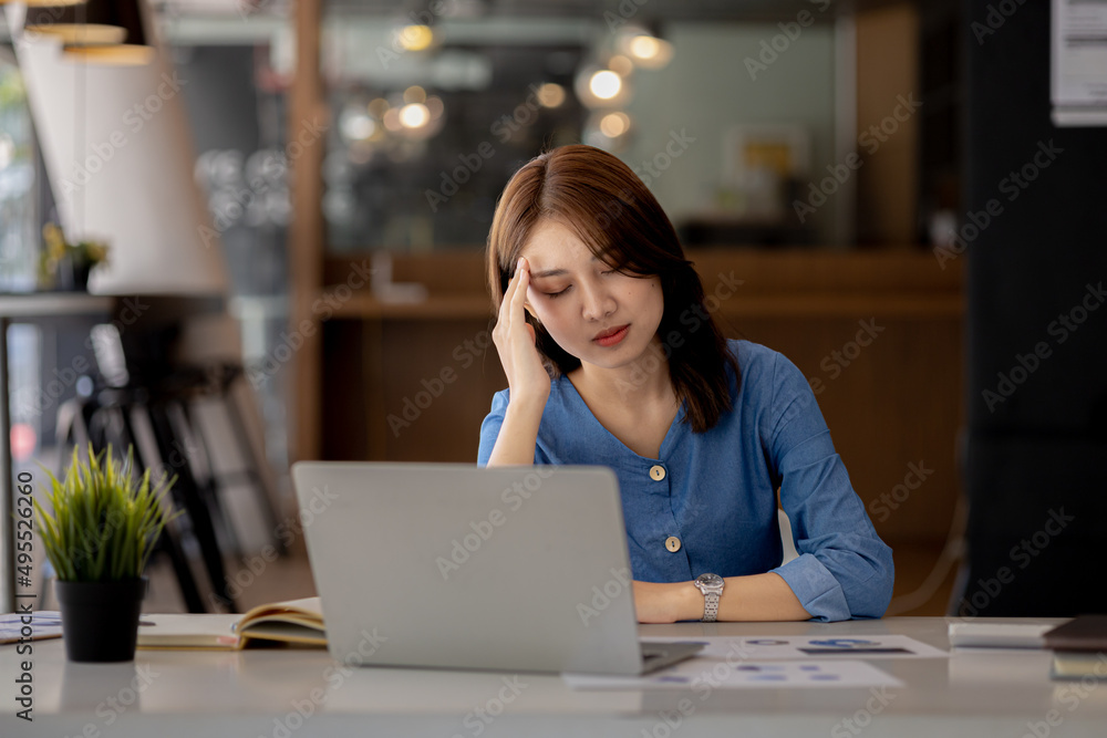 Beautiful Asian woman working in an office, she is a businesswoman who owns a company, she has a headache due to long and large paperwork leaving her tired and dizzy. The concept of sickness from work Beautiful Asian woman working in an office, she is a businesswoman who owns a company, she has a headache due to long and large paperwork leaving her tired and dizzy. The concept of sickness from work