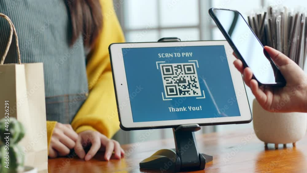 Customer using phone for payment at cafe restaurant, cashless QR code technology and money transfer concept
