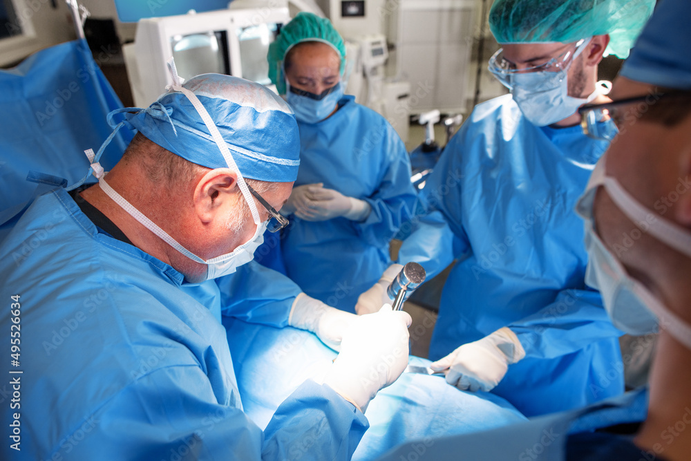 Surgeon operating on patient assisted by medical team Surgeon operating on patient assisted by medical team