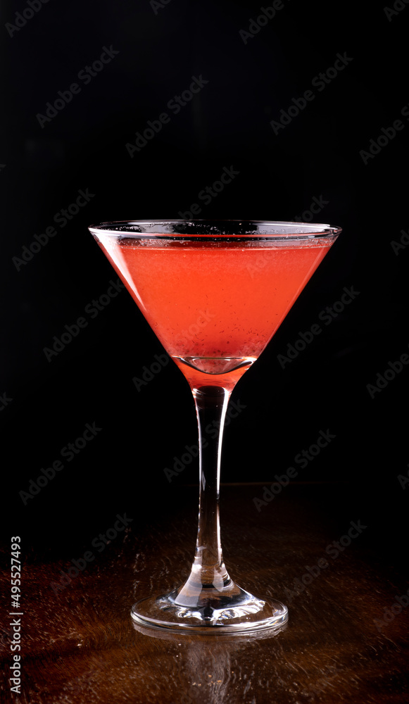 cosmopolitan cocktail in martini glass on wooden table front view