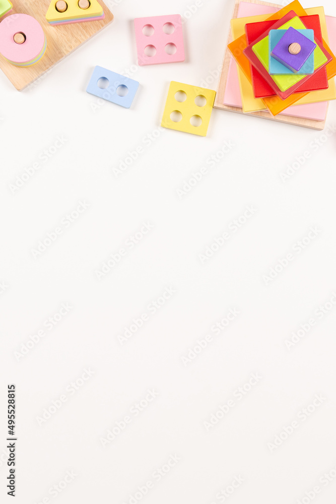 Baby kids toys frame on white background. Many colorful Montessori educational wooden toys. Top view, flat lay, copy space for text Baby kids toys frame on white background. Many colorful Montessori educational wooden toys. Top view, flat lay, copy space for text