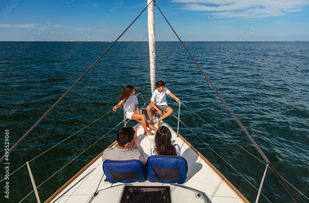 Obraz premium Young Hispanic family sitting together on private yacht
