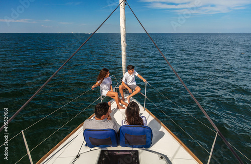 Young Hispanic family sitting together on private yacht