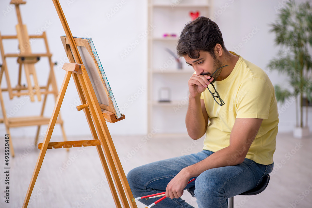 Young man enjoying painting at home