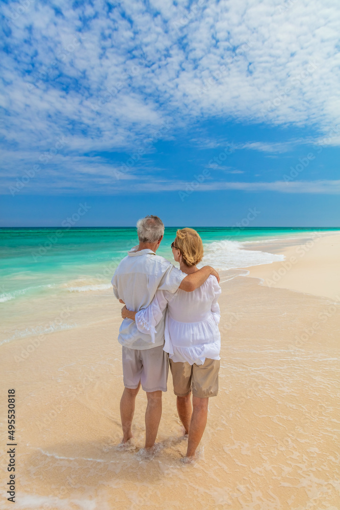 Senior couple on shoreline enjoying togetherness in retirement
