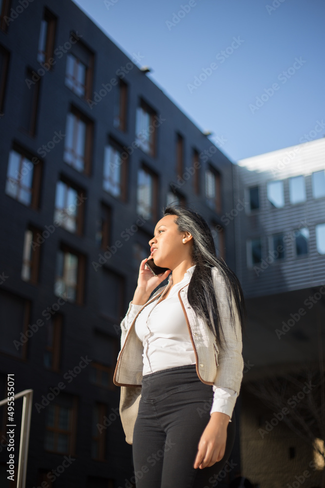 Young businesswoman using phone outdoors at the modern office district Young businesswoman using phone outdoors at the modern office district