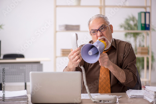 Angry boss employee holding megaphone at workplace photo