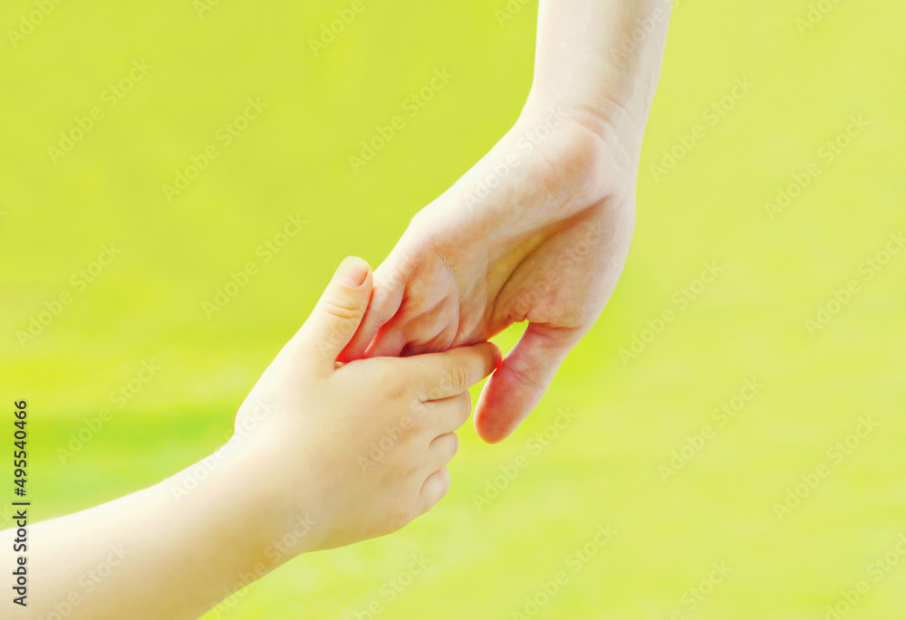 Naklejka premium Close up hand child and hand mother outdoors