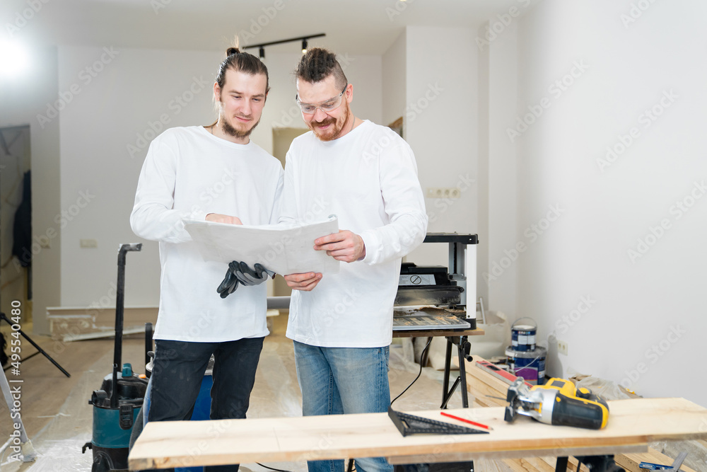 engineers with design project of furniture or apartment on construction site. engineers with design project of furniture or apartment on construction site.