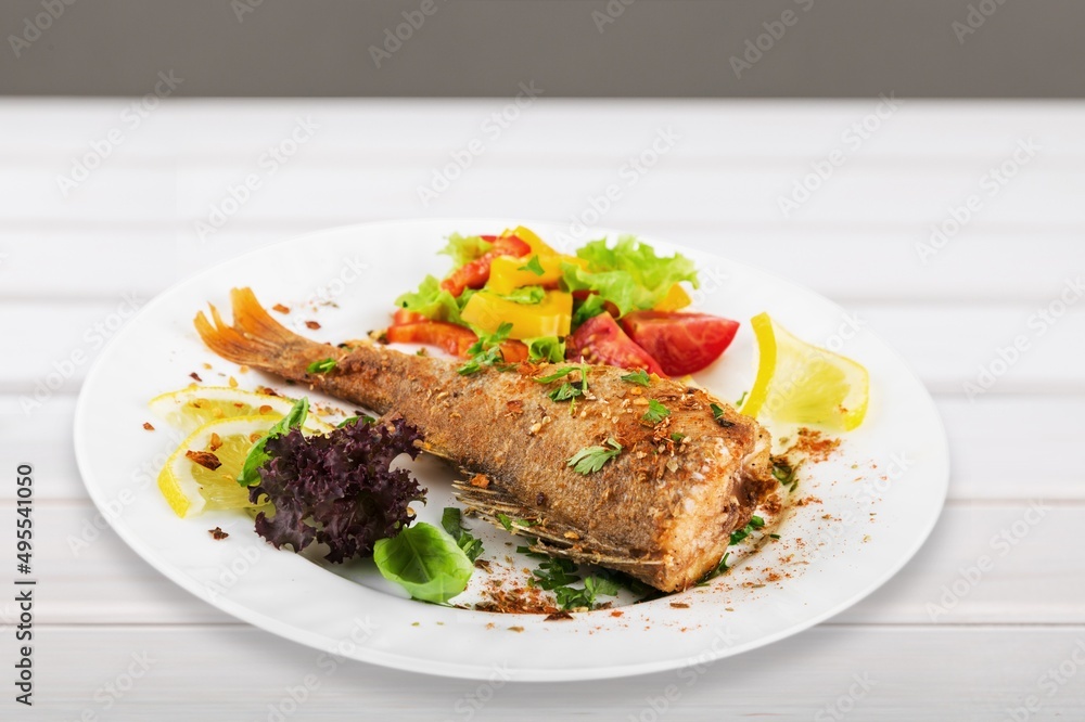 Fried salmon with vegetableson plate. Sprinkled with sesame seeds.