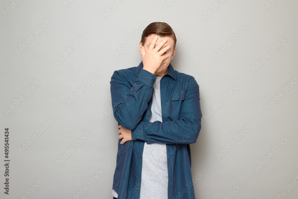 Portrait of unhappy disappointed mature man making facepalm gesture Portrait of unhappy disappointed mature man making facepalm gesture