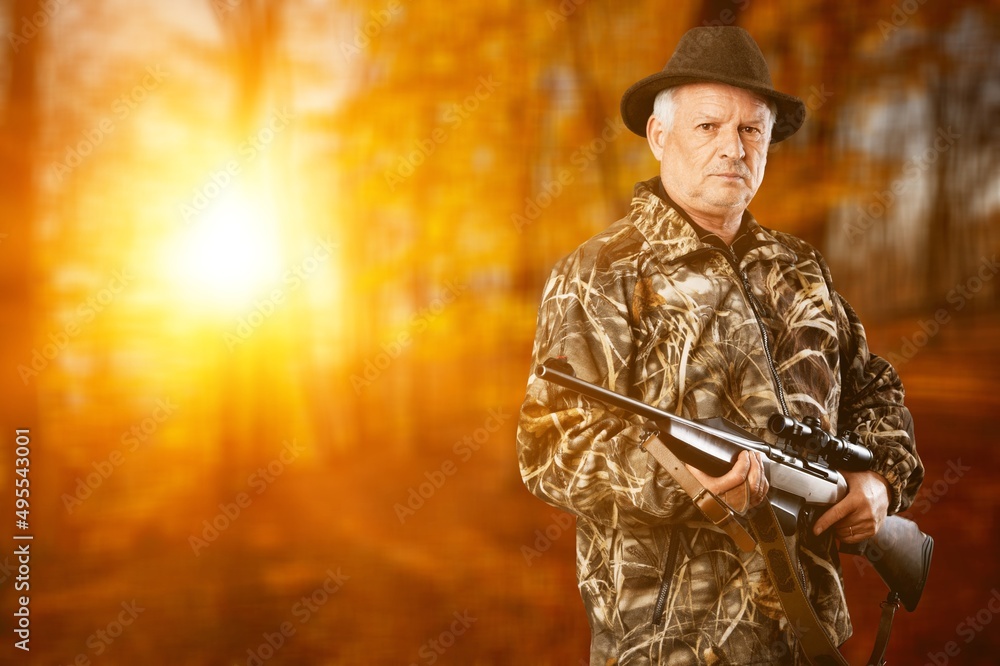 Male hunter in forest clothes holding gun ready to hunt, and walking in forest. Hunting and people concept. Male hunter in forest clothes holding gun ready to hunt, and walking in forest. Hunting and people concept.