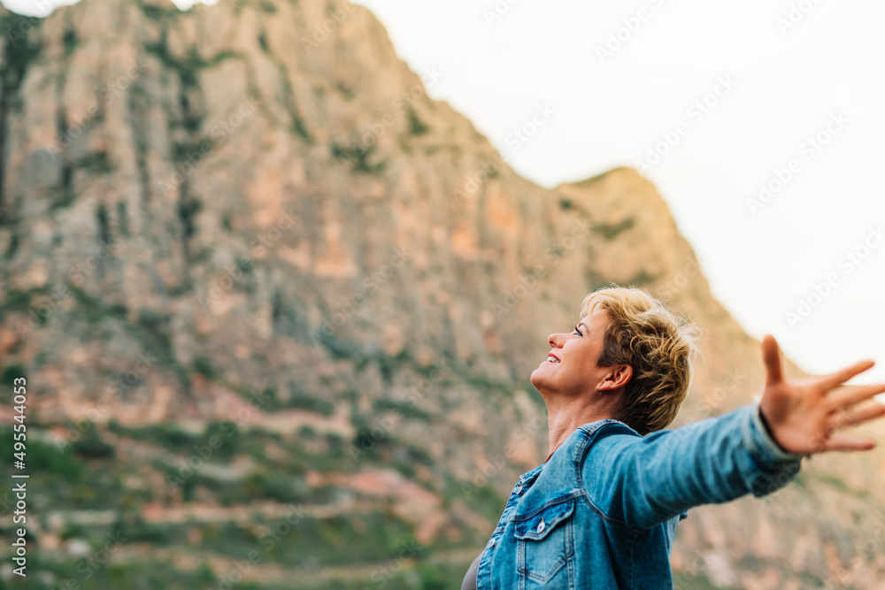 portrait of an adult woman, on holiday enjoying the scenery with her arms outstretched. portrait of an adult woman, on holiday enjoying the scenery with her arms outstretched.