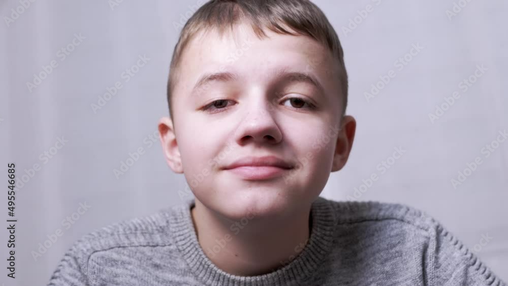 Portrait of Smiling Happy Laughing Boy Looking at Camera. Face of a teenager is close-up. Smile. A beautiful caucasian child opens his mouth, shows teeth, squints blinks his eyes. Child in the room. Portrait of Smiling Happy Laughing Boy Looking at Camera. Face of a teenager is close-up. Smile. A beautiful caucasian child opens his mouth, shows teeth, squints blinks his eyes. Child in the room.