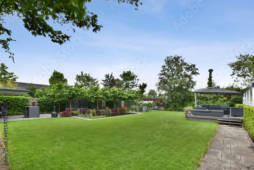 Fotografía The backyard of the house with a large green lawn, a small swimming pool and a s