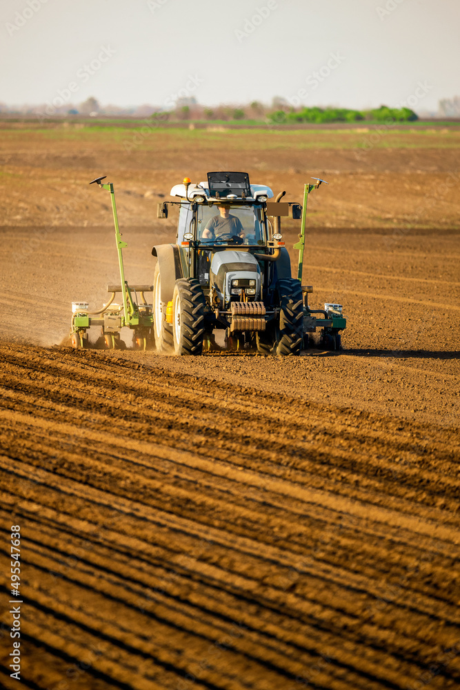 Fototapeta premium Tractor drilling seeding crops at farm field. Agricultural activity.