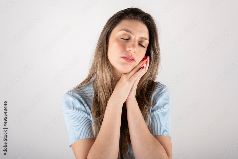 Portrait of a young blond woman daydreaming, with a relaxed and positive attitude on a white background Portrait of a young blond woman daydreaming, with a relaxed and positive attitude on a white background