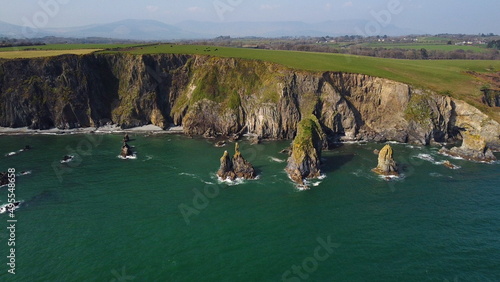 huge rocks and cliffs in the middle of the Atlantic Ocean in a UNESCO protected geopark, Stradbally Cove, on the Cooper Coast, Waterford, Ireland.