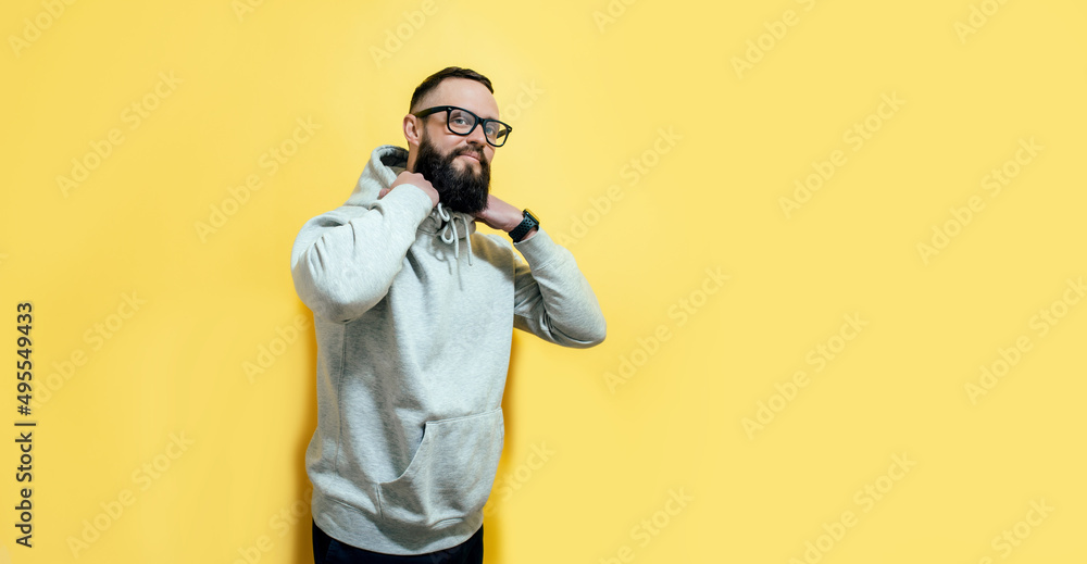 Studio portrait of handsome hipster guy with beard wearing gray blank hoodie with space for your logo or design. Mockup for print Studio portrait of handsome hipster guy with beard wearing gray blank hoodie with space for your logo or design. Mockup for print