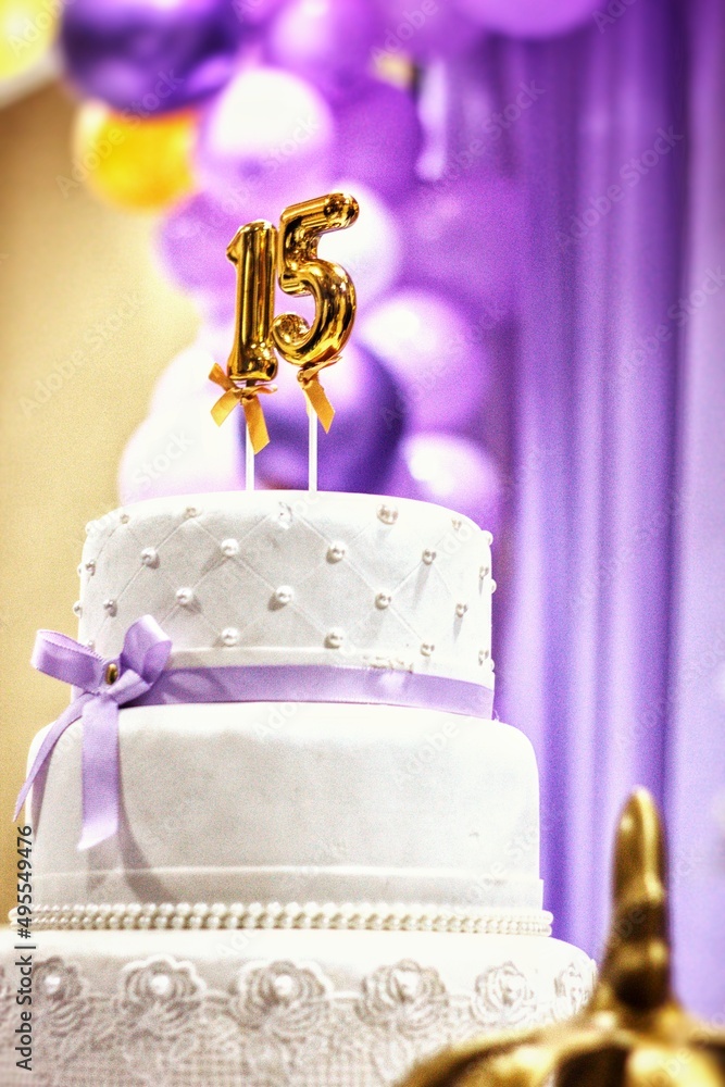 Foto de Bolo de Aniversário de Festa de 15 Anos Branco com Detalhes Lilás e  Velas Douradas - Baile de Debutante do Stock