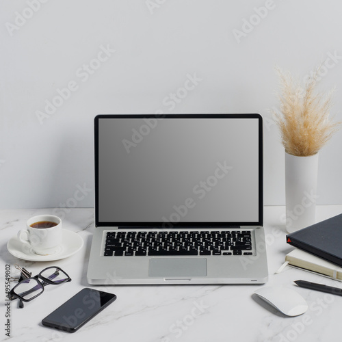 modern lap top template mock up on white and clean work desk with blank screen Workspace desk, laptop, coffee cup and pen. laptop mock up screen view. work from home concept