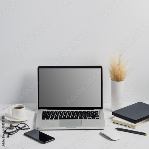 modern lap top template mock up on white and clean work desk with blank screen Workspace desk, laptop, coffee cup and pen. laptop mock up screen view. work from home concept