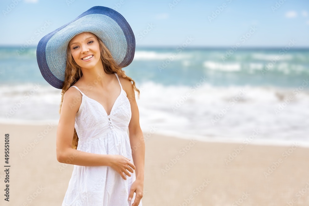 Beautiful woman with straw hat standing at beach. Young woman on vacation enjoy sea. Beautiful woman with straw hat standing at beach. Young woman on vacation enjoy sea.