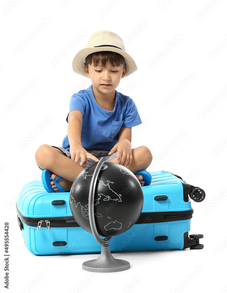 Fototapeta premium Little boy with globe and suitcase on white background