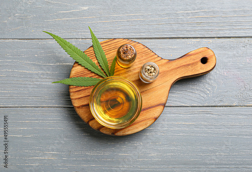 Bottle and bowl of CBD oil on wooden background photo