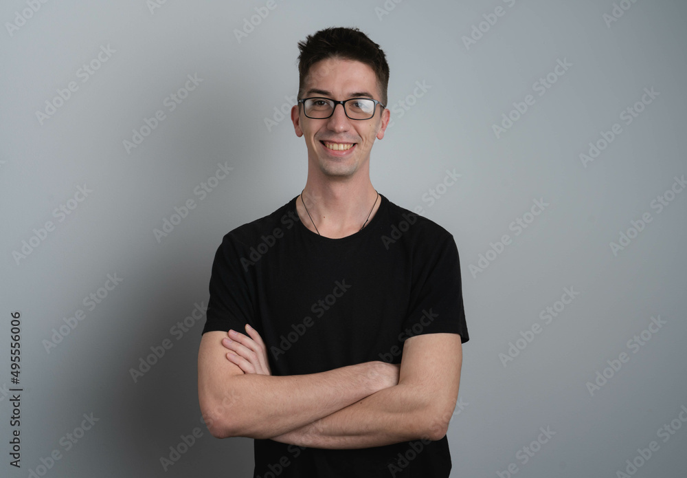 A male person in photo studio with crossed hands smiling A male person in photo studio with crossed hands smiling