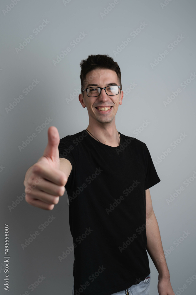 A male person in photo studio showing thumbs up in camera A male person in photo studio showing thumbs up in camera