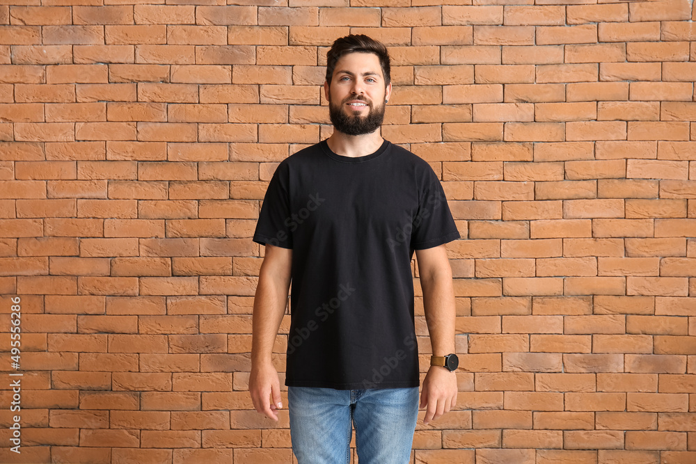 Handsome man in black t-shirt on brick background Handsome man in black t-shirt on brick background