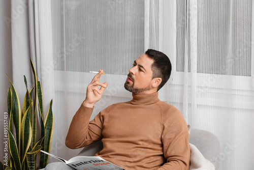 Handsome smoking man at home