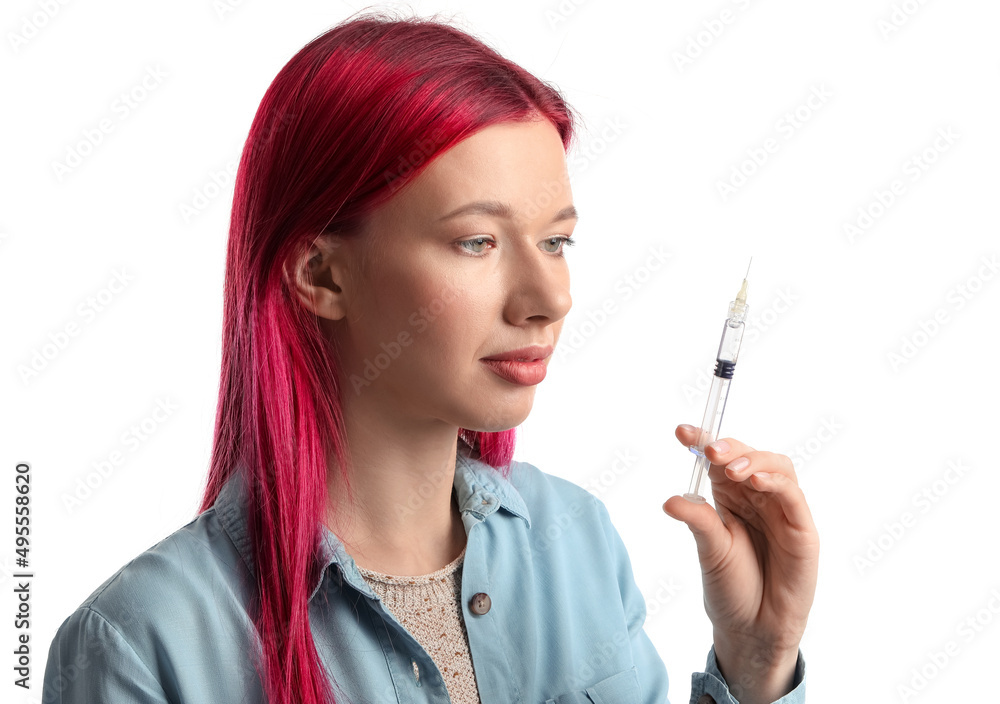 Obraz premium Young woman with bright hair and syringe on white background