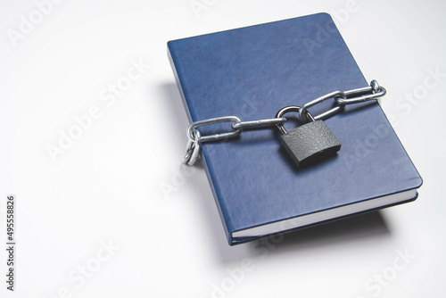 The book is locked under lock and key on a white background. Secret archive.