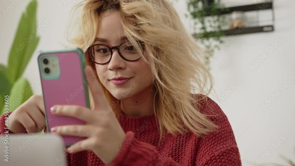 Blonde young Millenial girl on her cell phone. Social media. remote Work. Mobile Blonde young Millenial girl on her cell phone. Social media. remote Work. Mobile