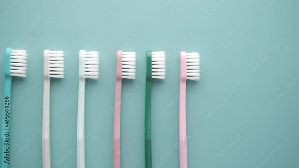 colorful toothbrushes on a light green background colorful toothbrushes on a light green background