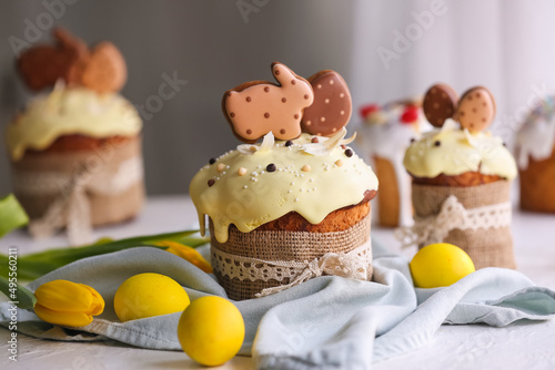 Delicious Easter cakes decorated with cookies and painted eggs on table in room, closeup © Pixel-Shot
