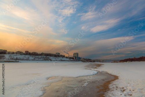 the setting sun beautifully illuminates the clouds over the city on a frosty winter evening