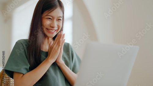 Excited asian female feeling euphoric celebrating online win success achievement result, young woman happy about good email news, motivated by great offer or new opportunity, passed exam, got a job photo