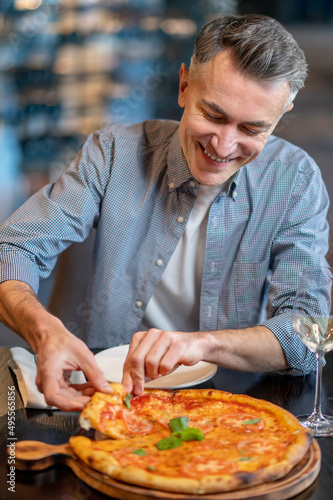 A man eating pizza and looking excited