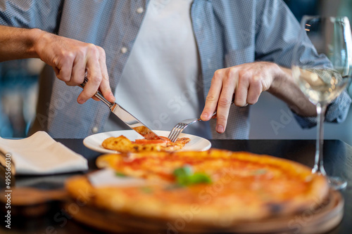 Fototapeta Naklejka Na Ścianę i Meble -  Close up picture of a ma cutting pizza