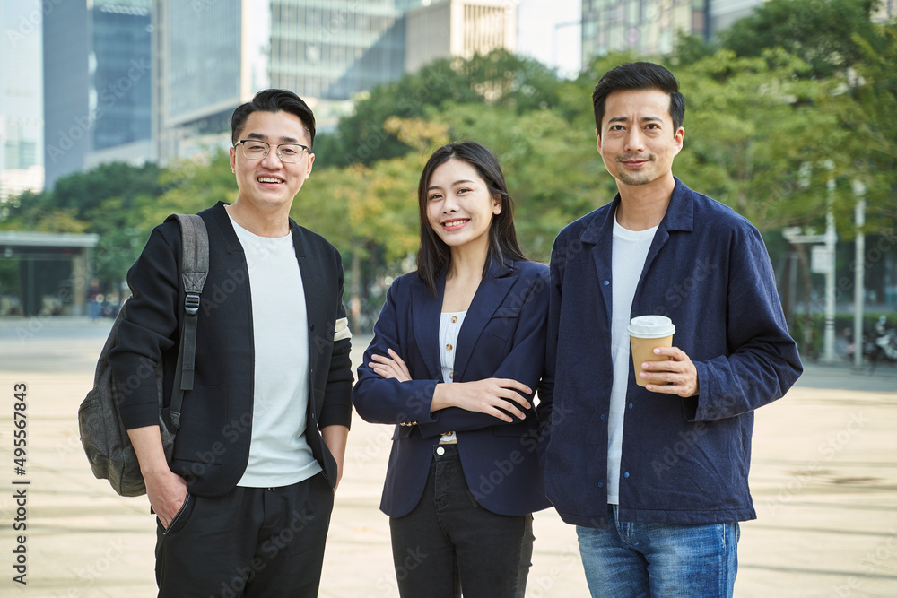 outdoor portrait of three young asian people in casual wear looking at camera smiling outdoor portrait of three young asian people in casual wear looking at camera smiling