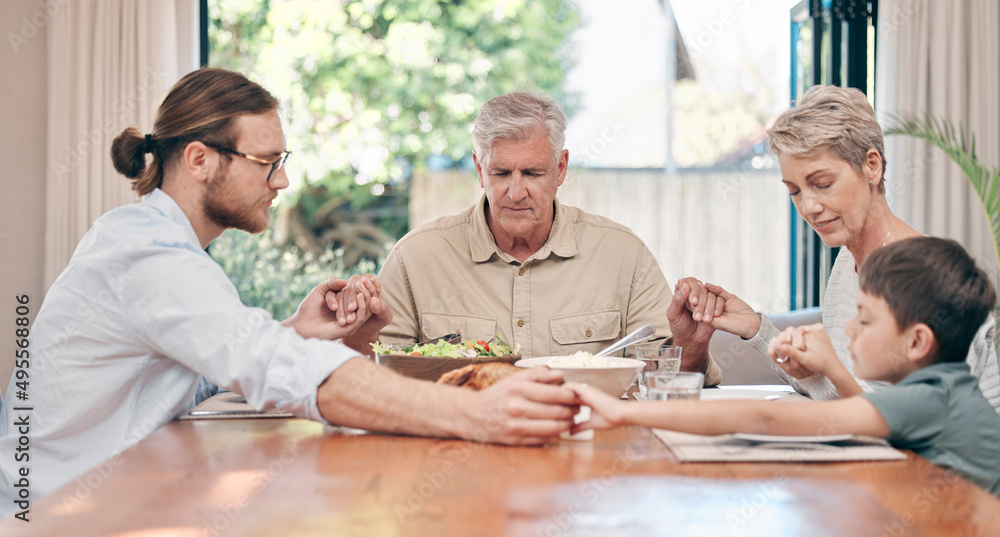 Thank you for the gift of family. Shot of a family holding hands in prayer before having a meal together at home. Thank you for the gift of family. Shot of a family holding hands in prayer before having a meal together at home.