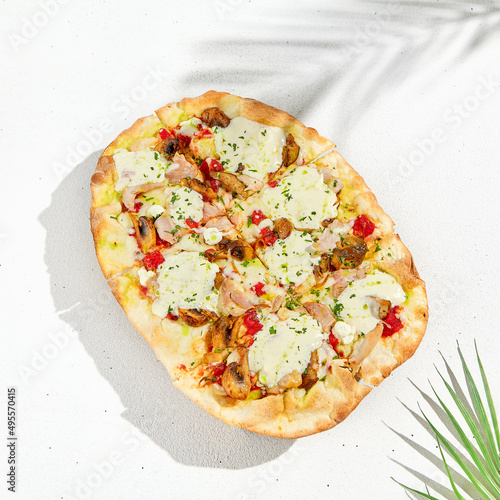 Roman pizza in summer style. Modern pinsa with mushrooms on white background. Roman pizza with mushrooms, ham, tomato sauce and mozzarella cheese photo