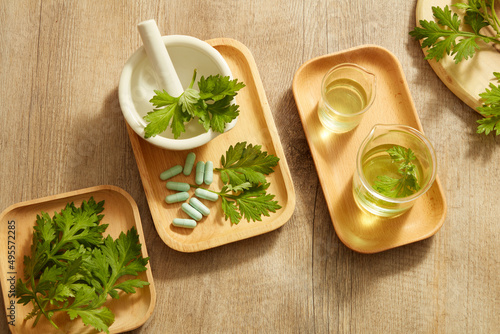 Top view of mugwort decorated with mortar and pestile wooden dish in wooden background for exfoliate advertising  photo