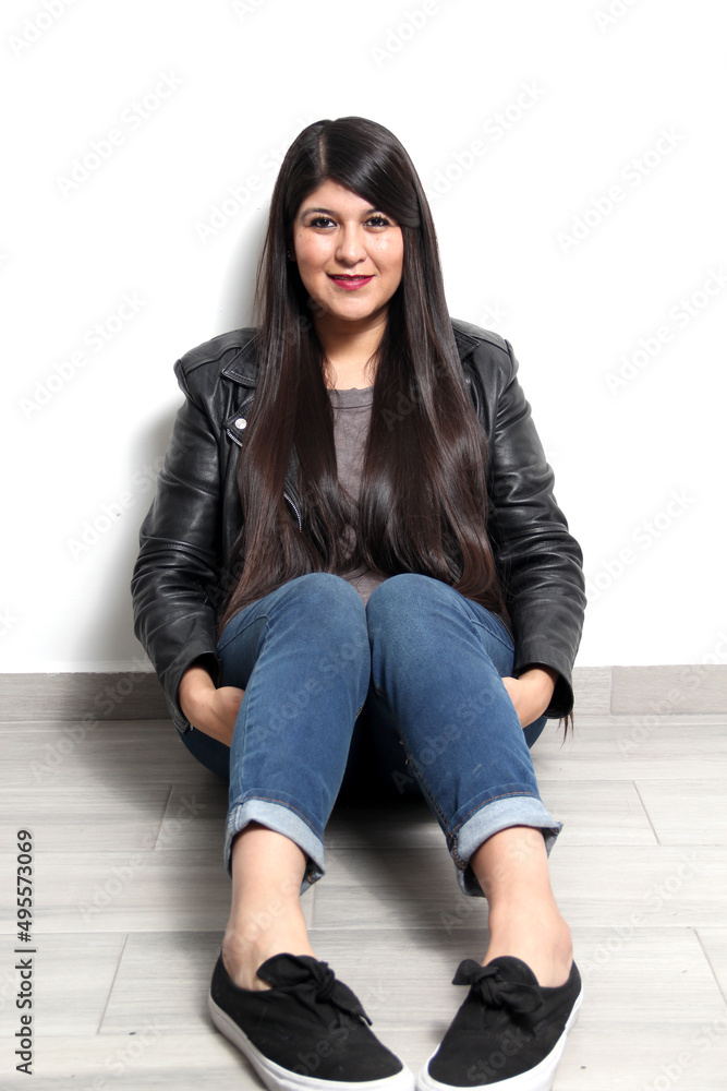 Happy and proud Latin young adult woman shows her long straight, black and shiny hair on a white background with a leather jacket and black tennis shoes
Happy and proud Latin young adult woman shows her long straight, black and shiny hair on a white background with a leather jacket and black tennis shoes